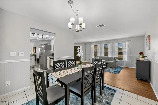 a view of a dining room with furniture a chandelier and wooden floor