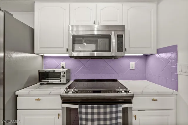 a stove top oven sitting inside of a kitchen