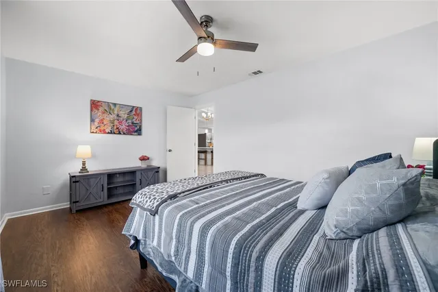 a spacious bedroom with a bed and a chandelier