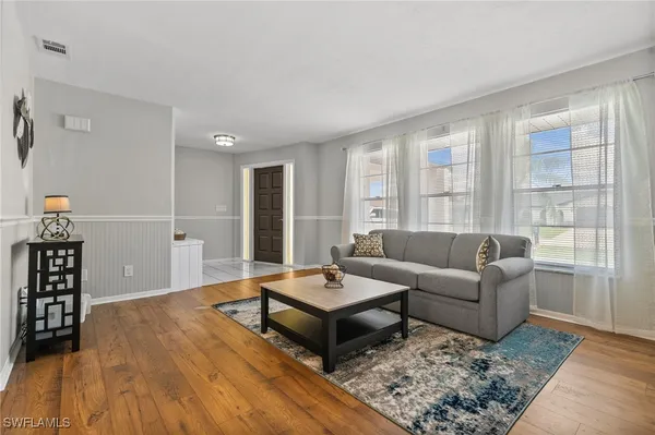 a living room with furniture and wooden floor