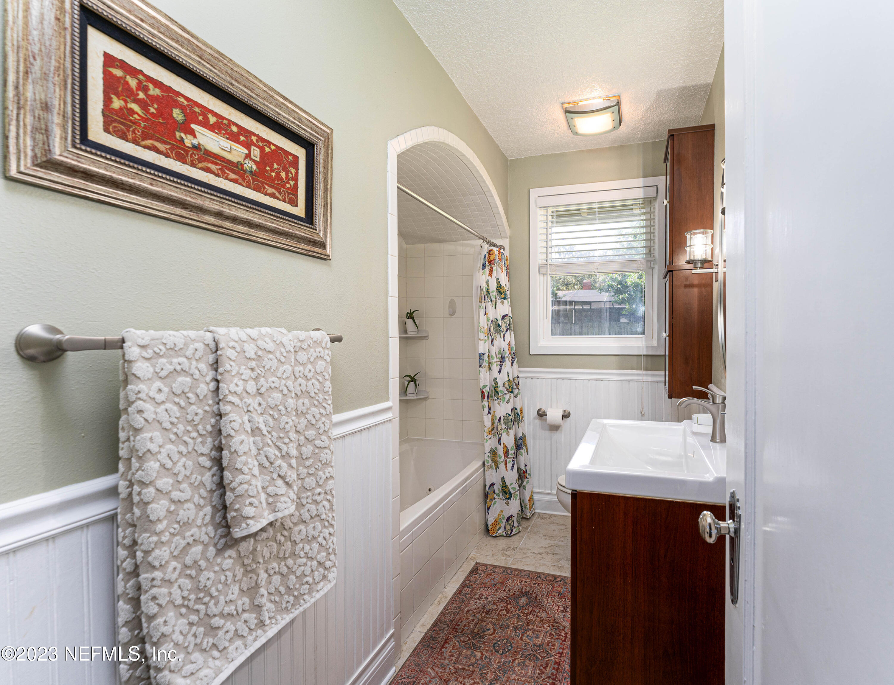 1544 Lorimier Road Jacksonville, FL 32207 - Photo 18 of 27 a bathroom with a sink and mirror with bathtub
