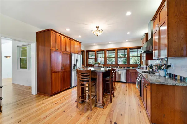 a large kitchen with kitchen island granite countertop a sink and a large window