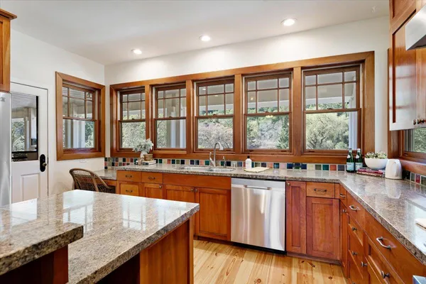 a kitchen with granite countertop stainless steel appliances a stove a sink and dishwasher