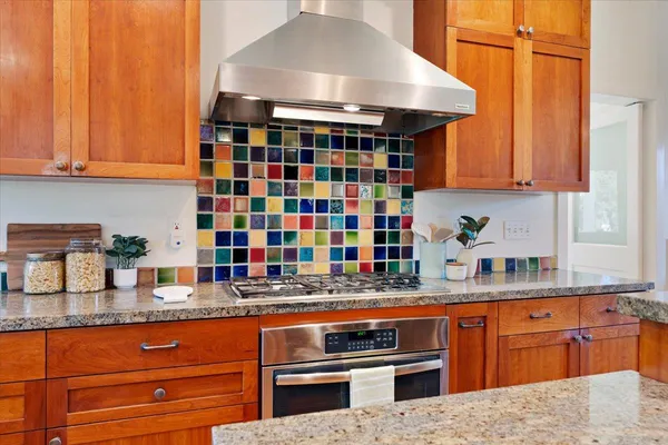 a kitchen with stainless steel appliances granite countertop a stove a refrigerator a sink dishwasher with a dining table and chairs with wooden floor