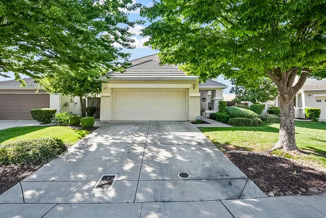 a front view of a house with a yard and a garage