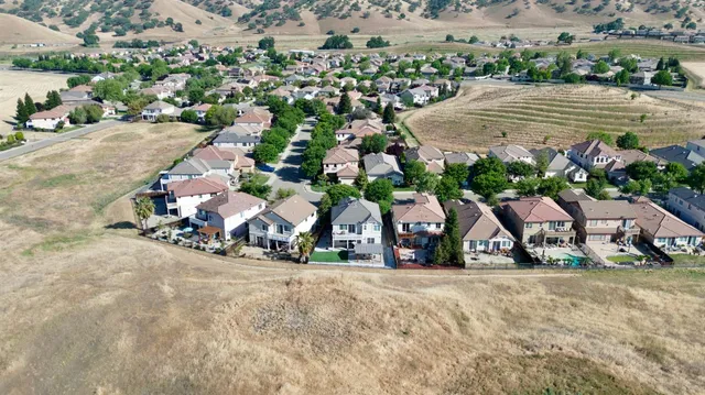 an aerial view of a house with a yard and parking spaces
