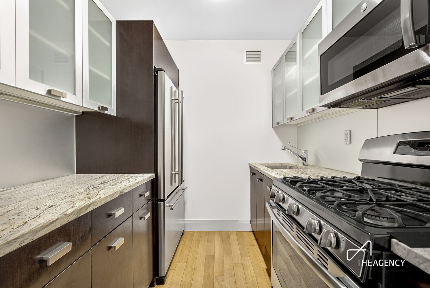 212 East 47th Street, Unit 34C Manhattan, NY 10017 - Photo 5 of 9 a kitchen with granite countertop a stove and a sink