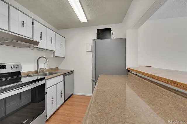 a kitchen with stainless steel appliances a sink stove and cabinets