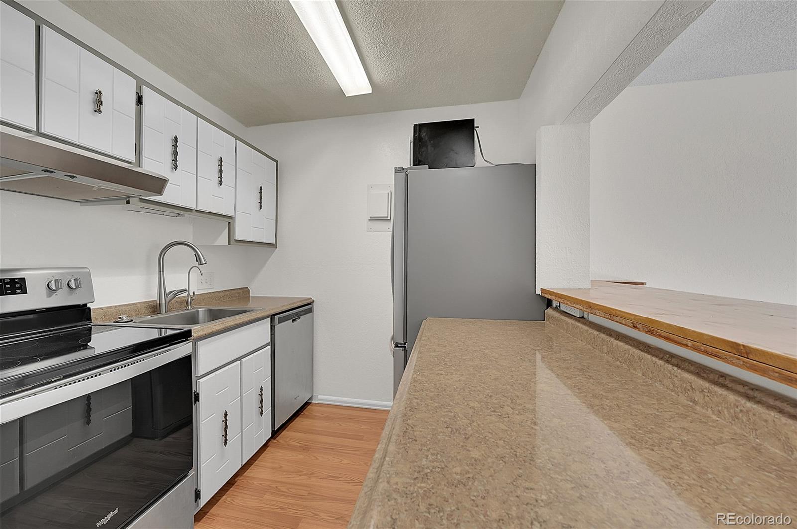 3250 Oneal Circle, Unit 25J Boulder, CO 80301 - Photo 4 of 22 a kitchen with stainless steel appliances a sink stove and cabinets