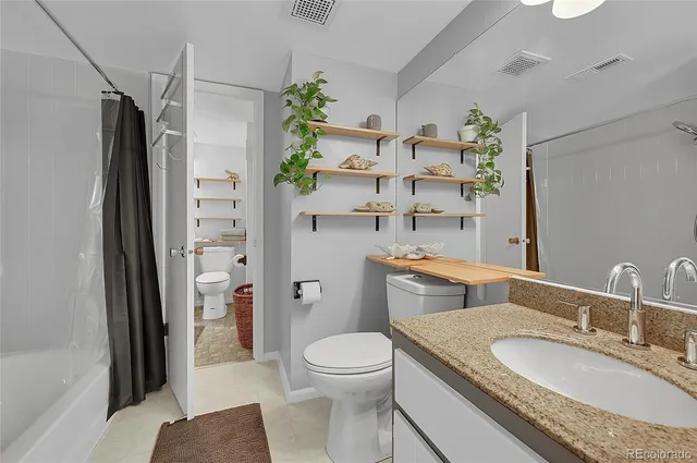 a bathroom with a granite countertop toilet sink and shower