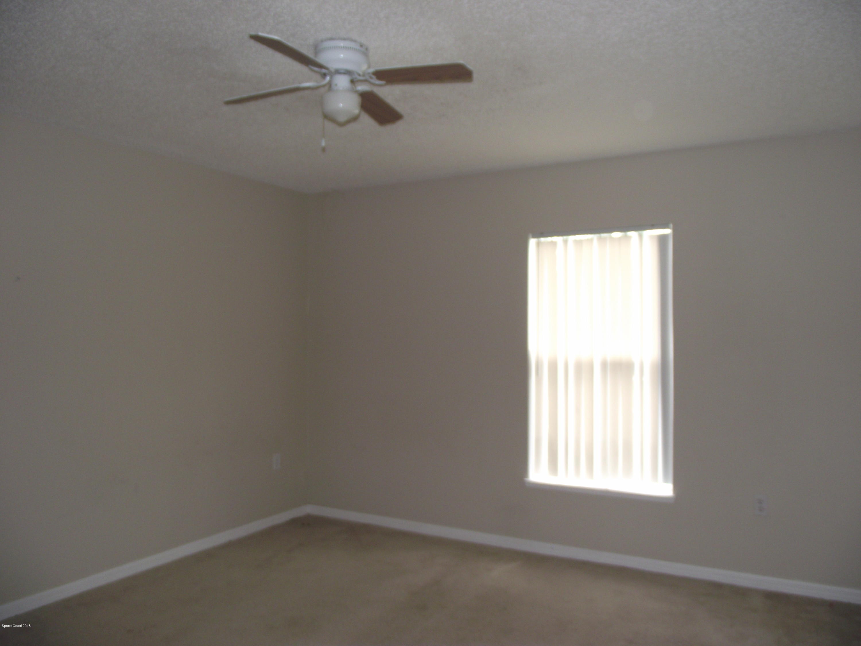 1006 Ray Road Southeast Palm Bay, FL 32909 - Photo 13 of 21 an empty room with a window and a fan