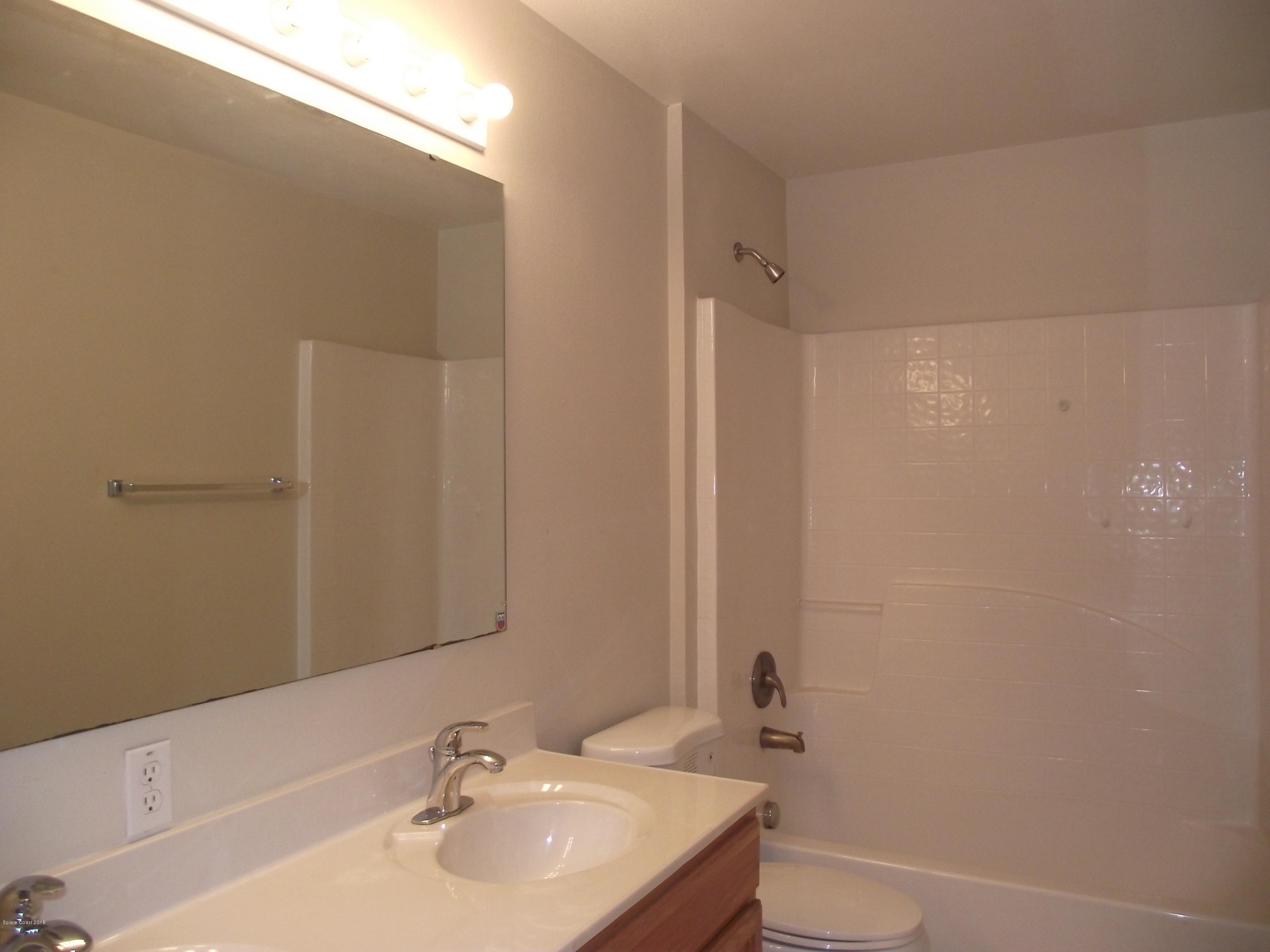 1006 Ray Road Southeast Palm Bay, FL 32909 - Photo 14 of 21 a bathroom with a sink a toilet and shower