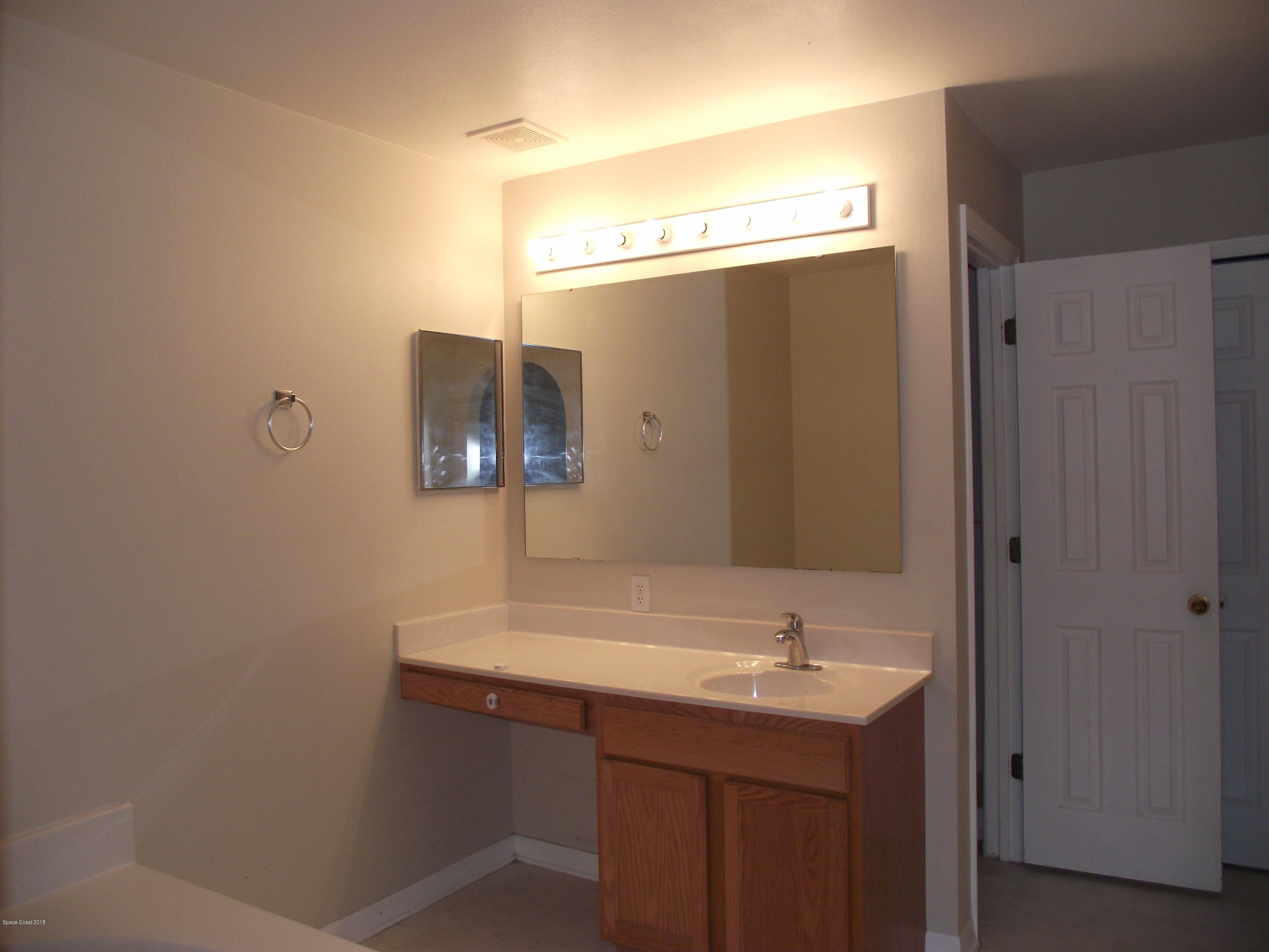 1006 Ray Road Southeast Palm Bay, FL 32909 - Photo 18 of 21 a bathroom with a sink and a mirror