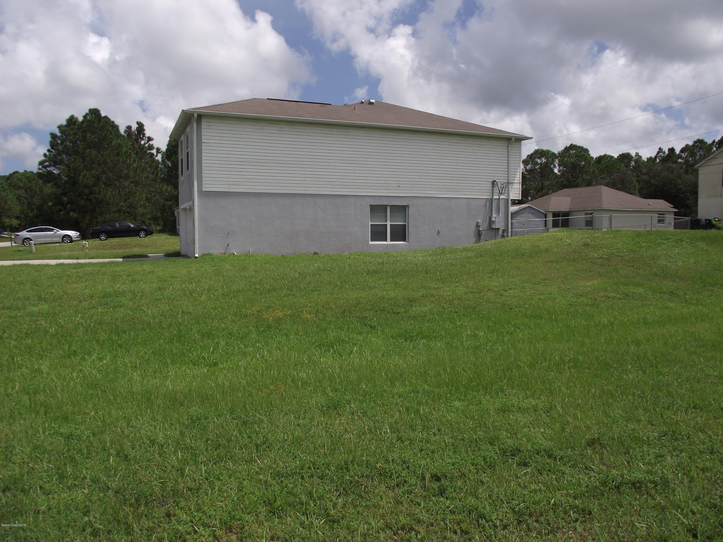 1006 Ray Road Southeast Palm Bay, FL 32909 - Photo 19 of 21 a view of a backyard with plants and a garage