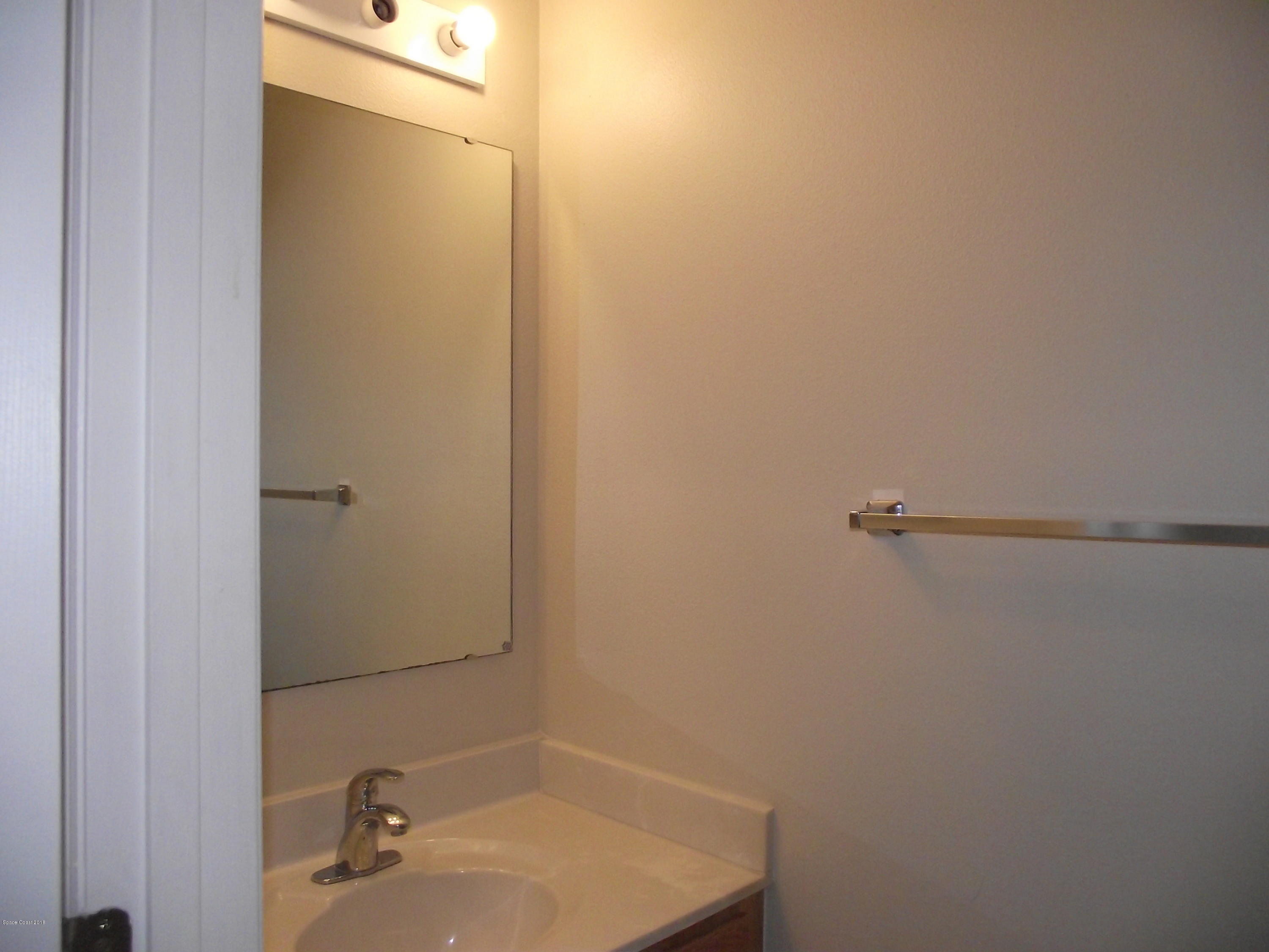 1006 Ray Road Southeast Palm Bay, FL 32909 - Photo 8 of 21 a bathroom with a sink and mirror