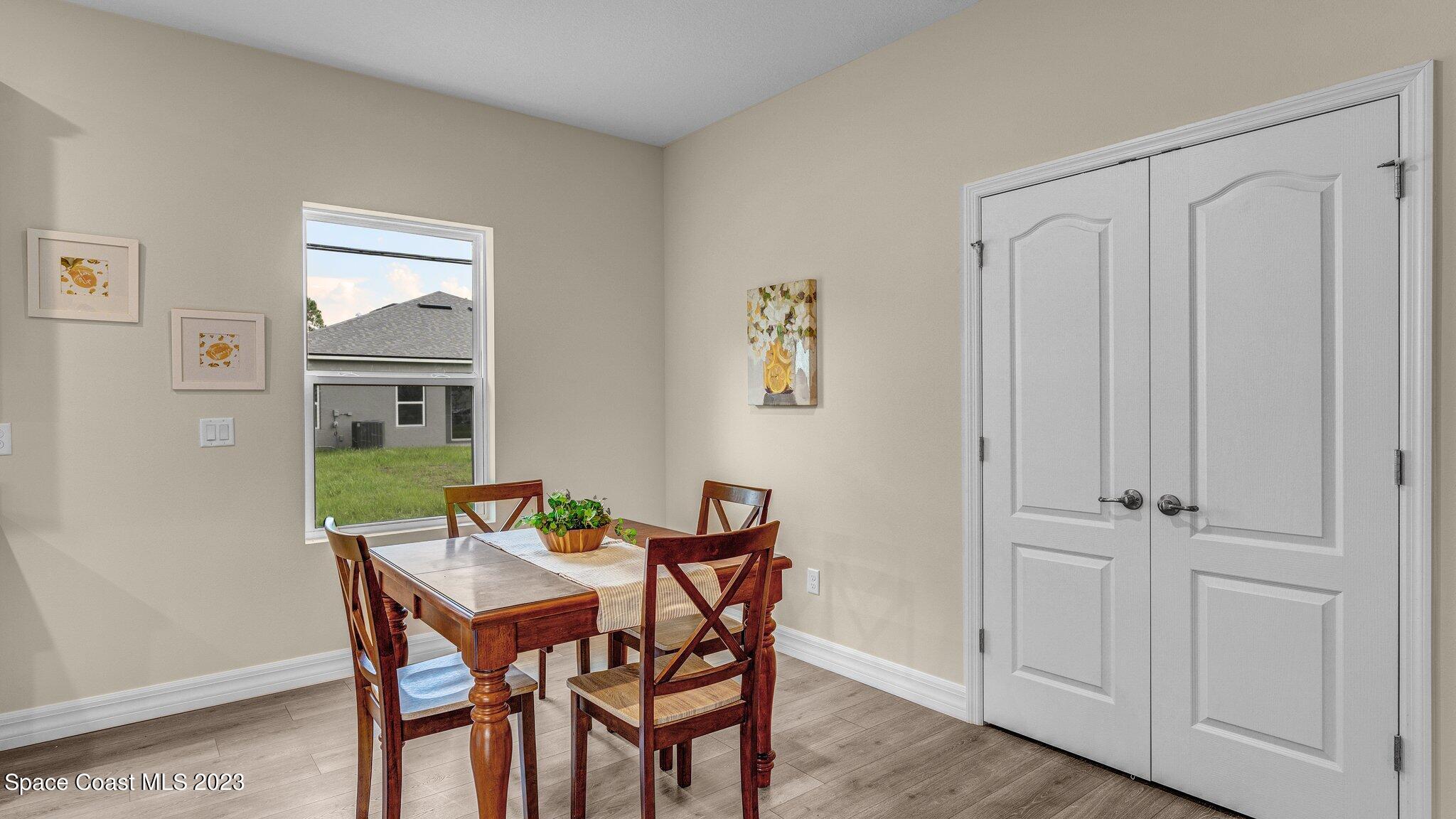491 Tilhal Road Southwest Palm Bay, FL 32908 - Photo 11 of 30 a view of a dining room with furniture and wooden floor
