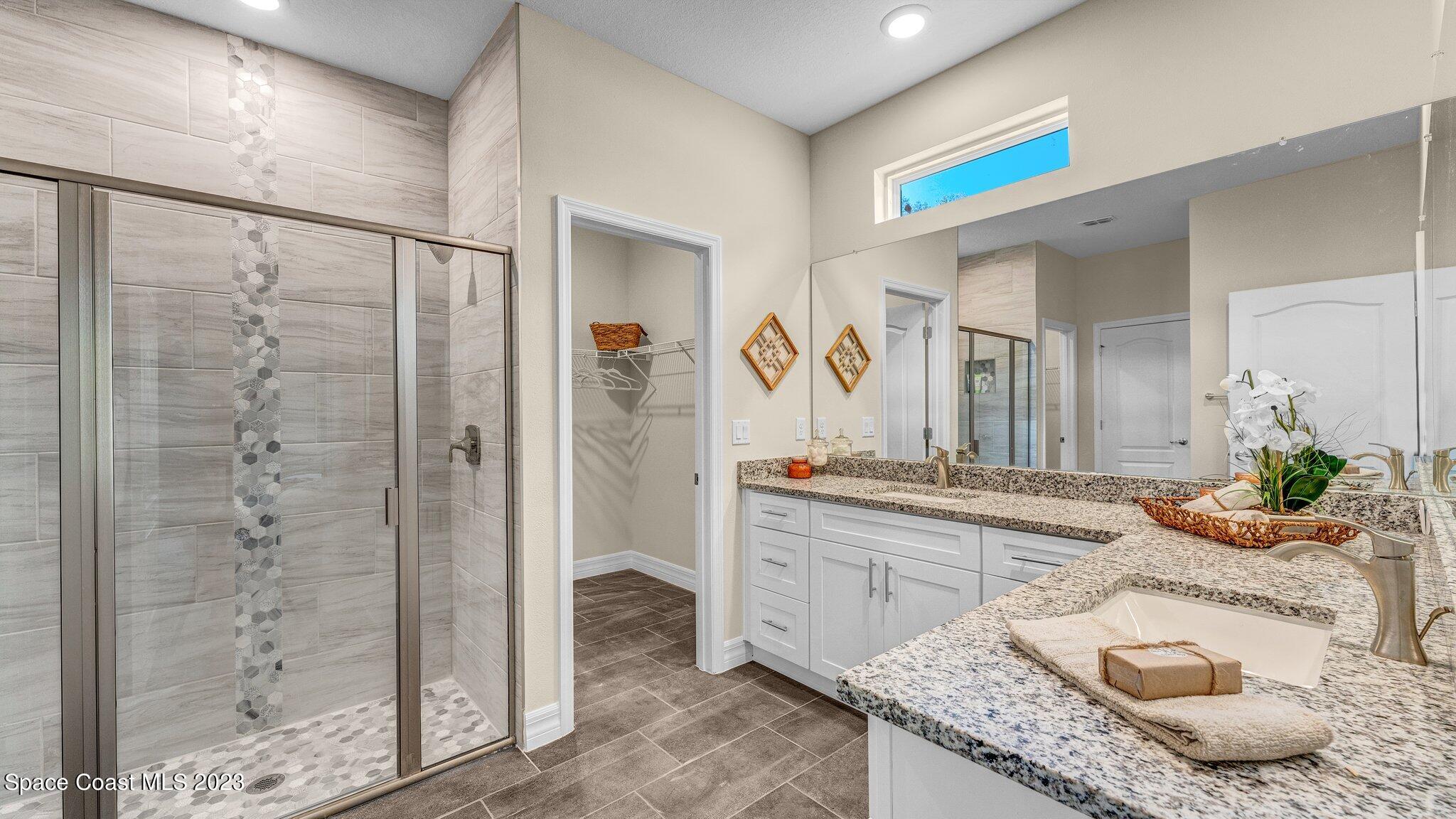 491 Tilhal Road Southwest Palm Bay, FL 32908 - Photo 17 of 30 a bathroom with a granite countertop sink a mirror and shower