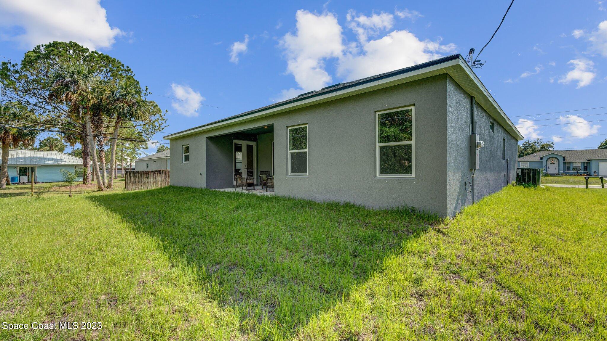 491 Tilhal Road Southwest Palm Bay, FL 32908 - Photo 28 of 30 a backyard of a house with table and chairs