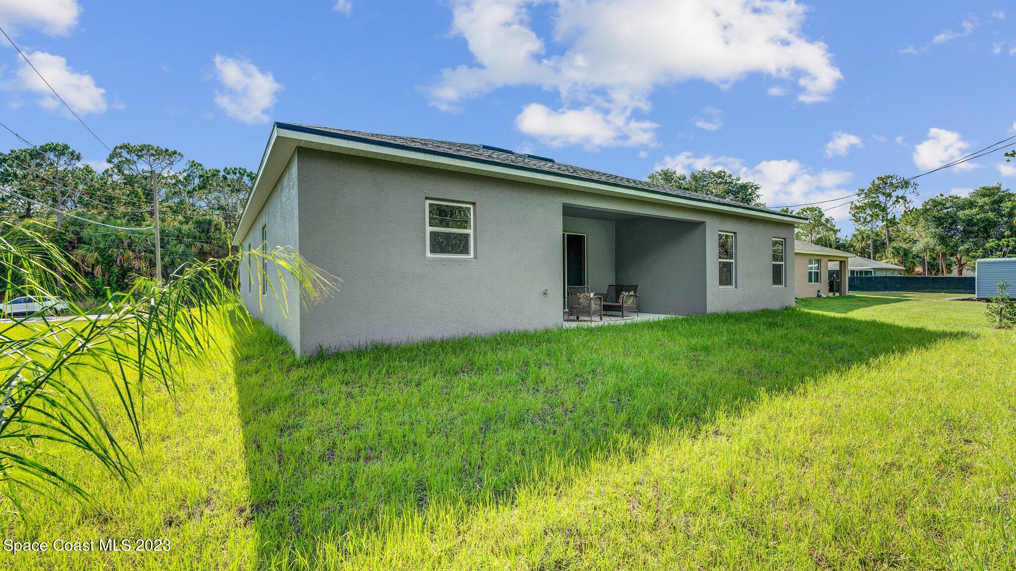 491 Tilhal Road Southwest Palm Bay, FL 32908 - Photo 29 of 30 a backyard of a house with plants and a garden