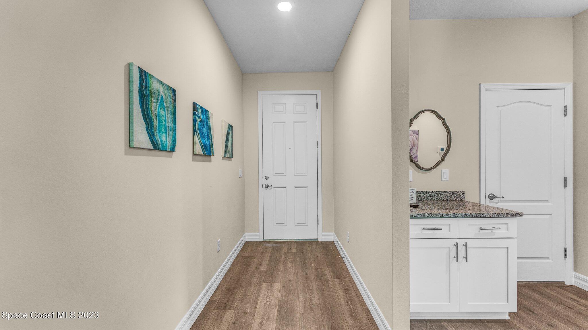 491 Tilhal Road Southwest Palm Bay, FL 32908 - Photo 2 of 30 a view of a hallway to closet and wooden floor