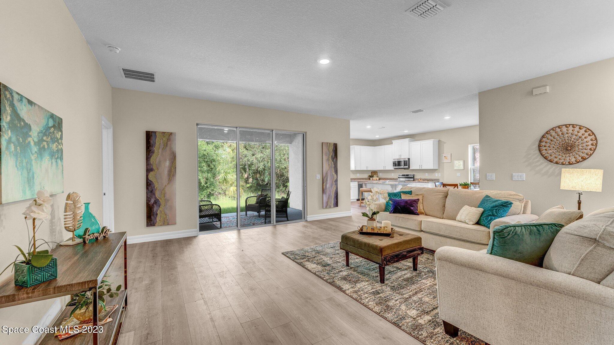 491 Tilhal Road Southwest Palm Bay, FL 32908 - Photo 3 of 30 a living room with furniture and wooden floor