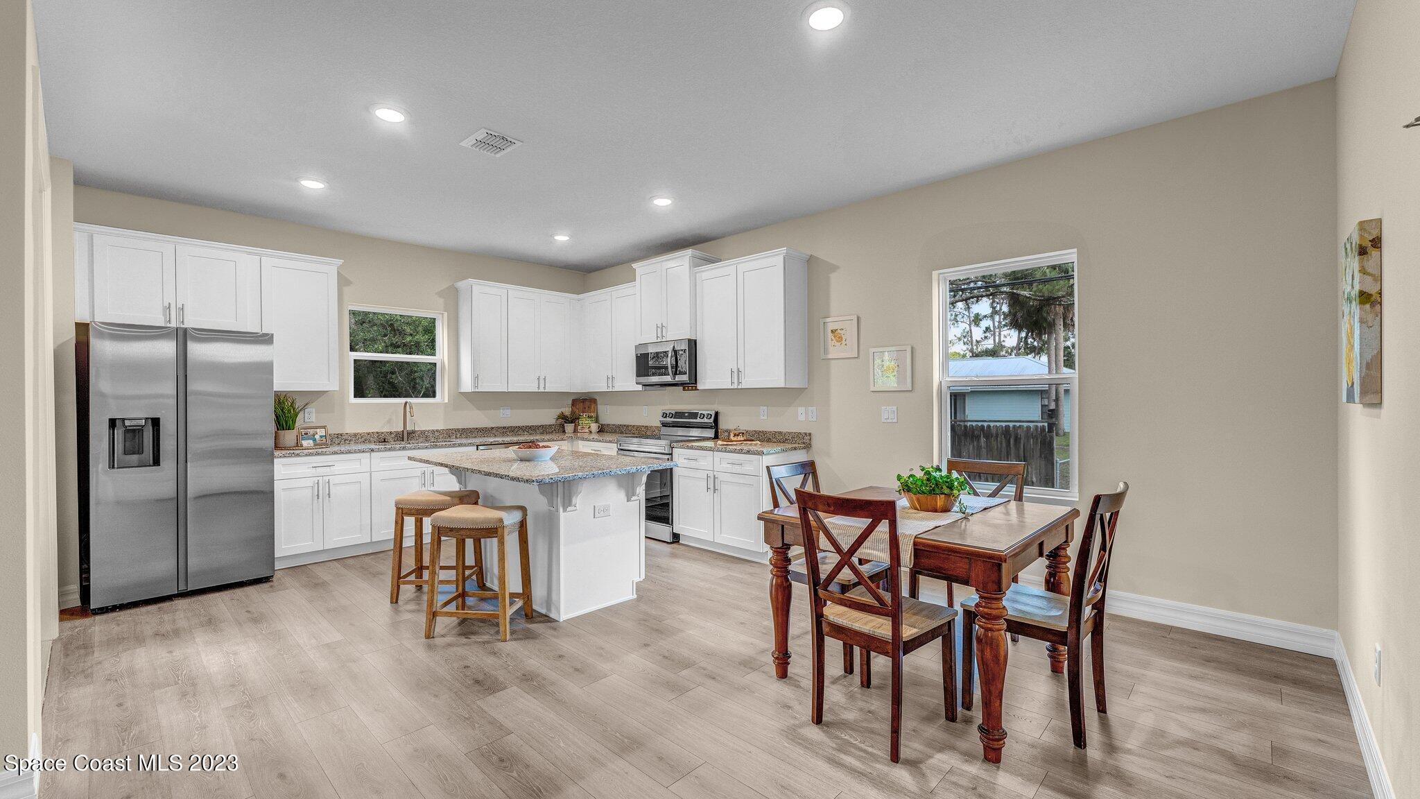 491 Tilhal Road Southwest Palm Bay, FL 32908 - Photo 8 of 30 a kitchen with a table and chairs