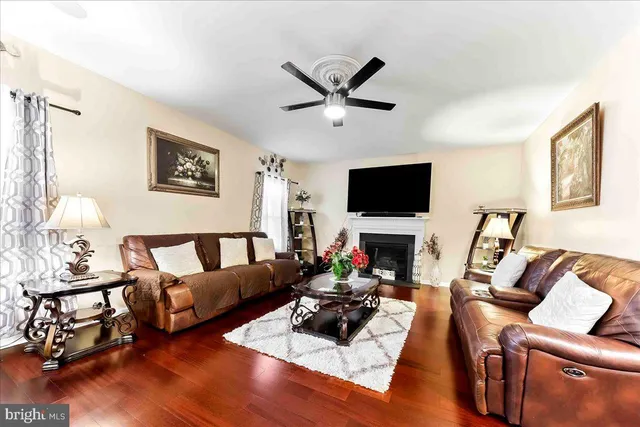 a living room with furniture kitchen view and a wooden floor