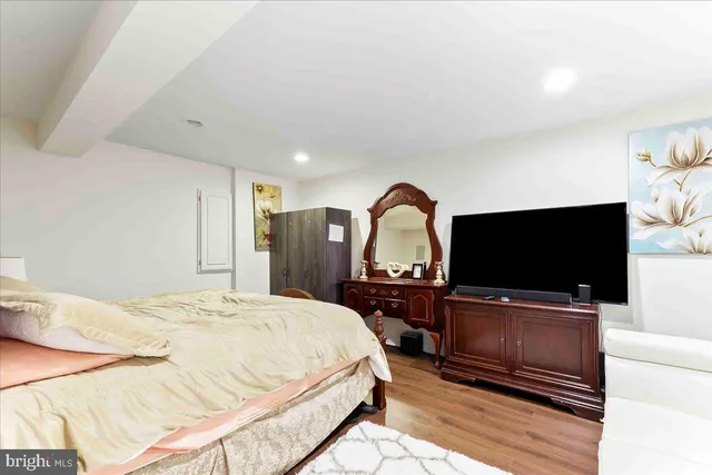 a bedroom with a bed and wooden floor