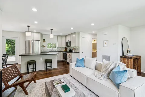 a living room with furniture and kitchen view