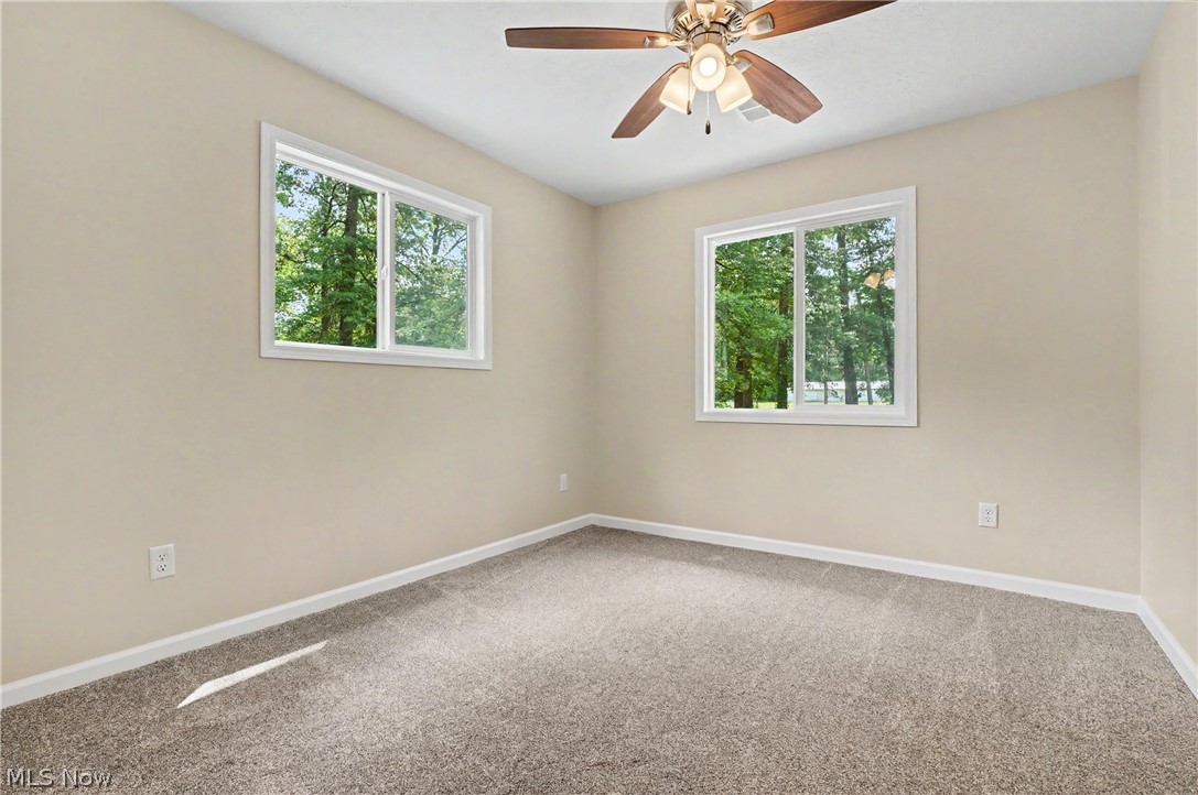 7583 Yale Road Atwater, OH 44201 - Photo 34 of 41 Bedroom four brand new 2026: paint, ceiling fan, windows, carpet, man door, closet doors, wood trim and baseboards.