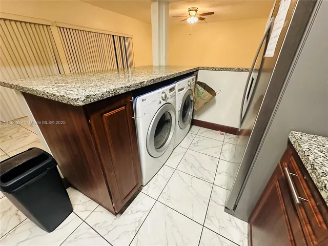 a utility room with granite countertop a sink a washer and dryer