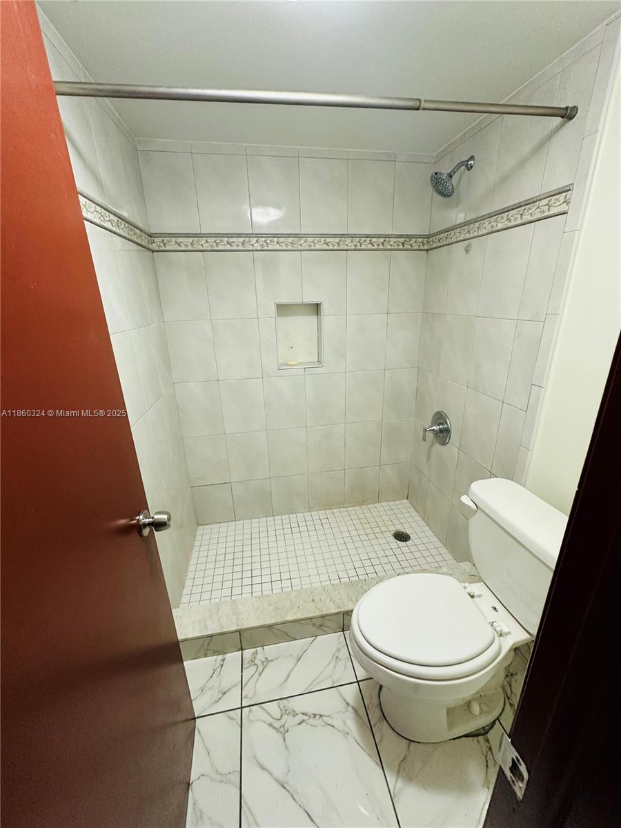 4850 Southwest 63rd Terrace, Unit 323 Davie, FL 33314 - Photo 7 of 12 a bathroom with a toilet and a shower