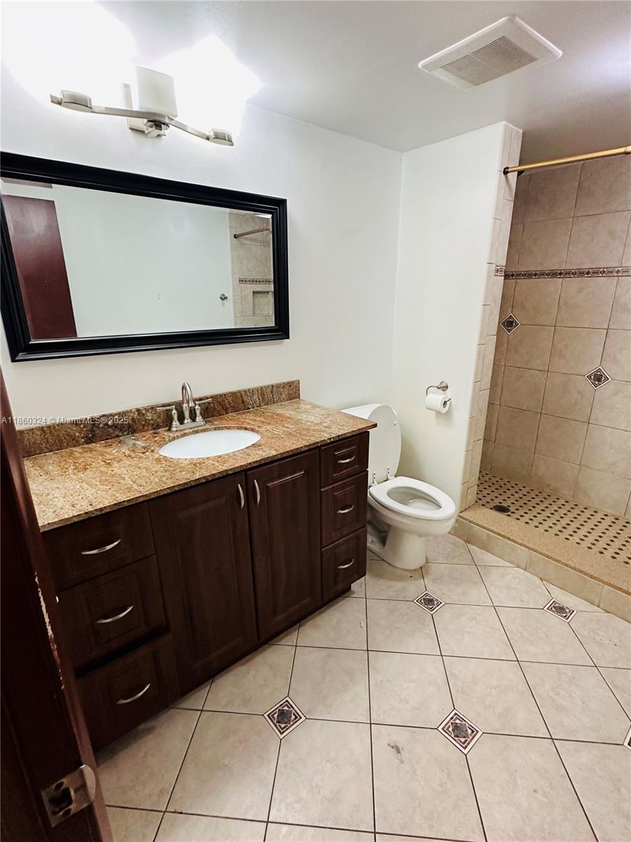 4850 Southwest 63rd Terrace, Unit 323 Davie, FL 33314 - Photo 10 of 12 a bathroom with a granite countertop sink a mirror and a toilet