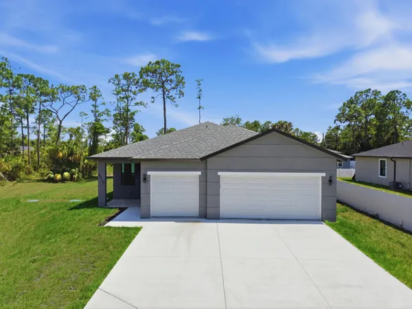 a front view of a house with a yard and a garage