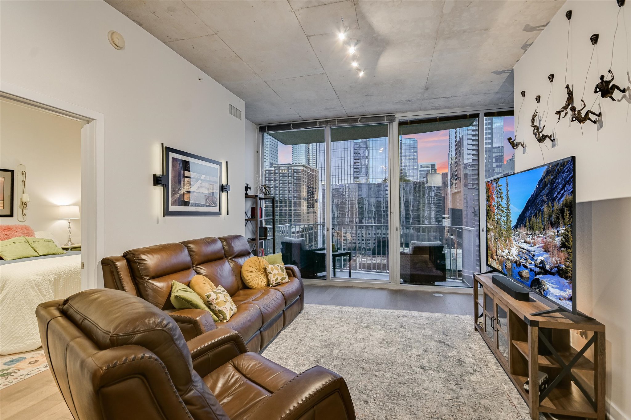 360 Nueces Street, Unit 1405 Austin, TX 78701 - Photo 13 of 40 a living room with furniture a flat screen tv and a floor to ceiling window