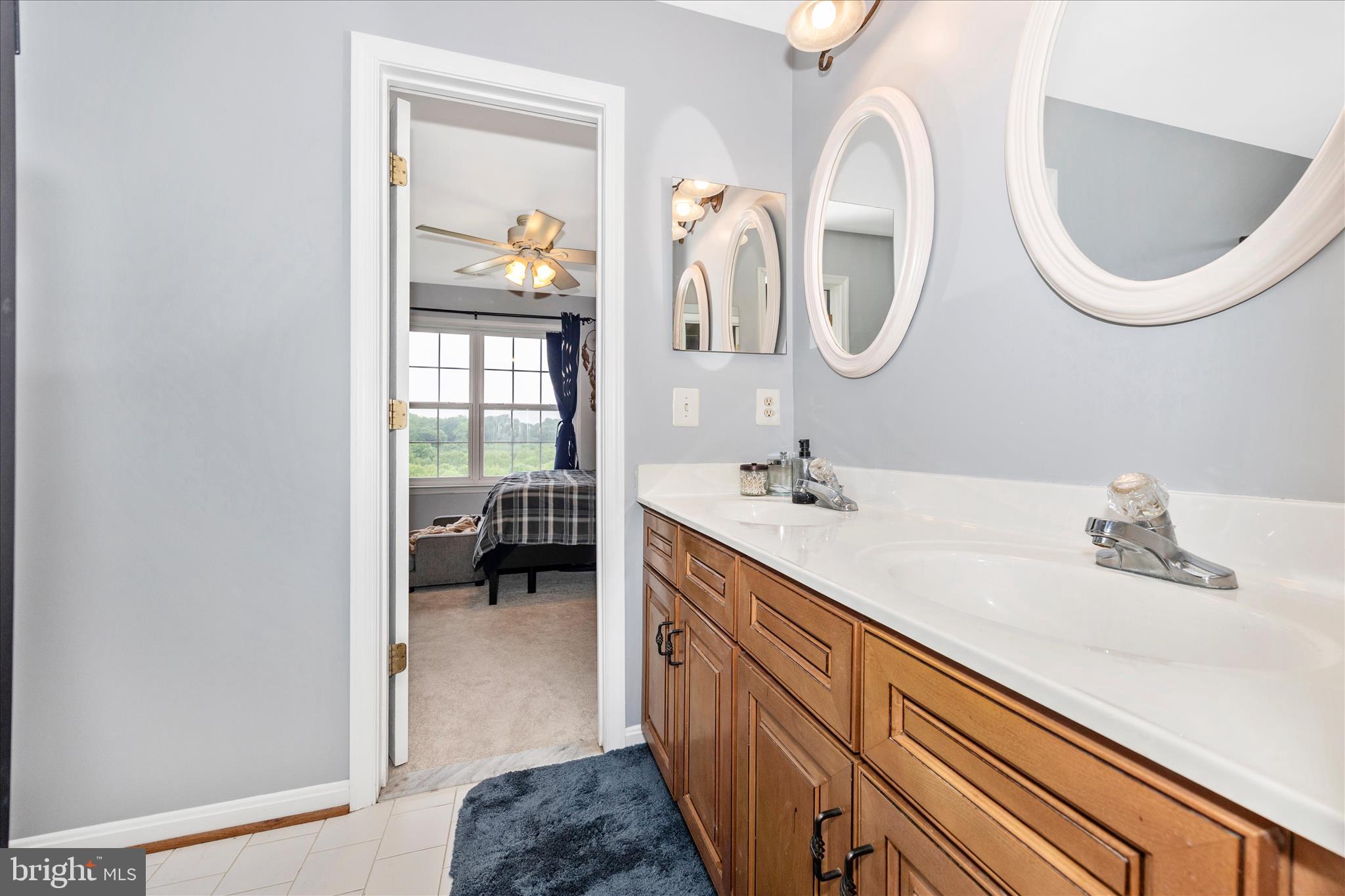 9855 McKinstry Mill Road New Windsor, MD 21776 - Photo 43 of 76 a en suite bathroom with a granite countertop double vanity sink and a mirror