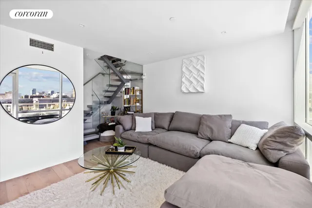 a living room with furniture and a floor to ceiling window