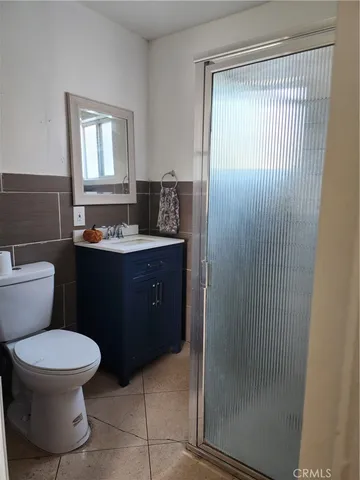 a bathroom with a toilet sink vanity and mirror