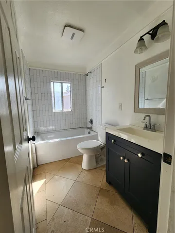 a bathroom with a double vanity sink toilet mirror and bathtub