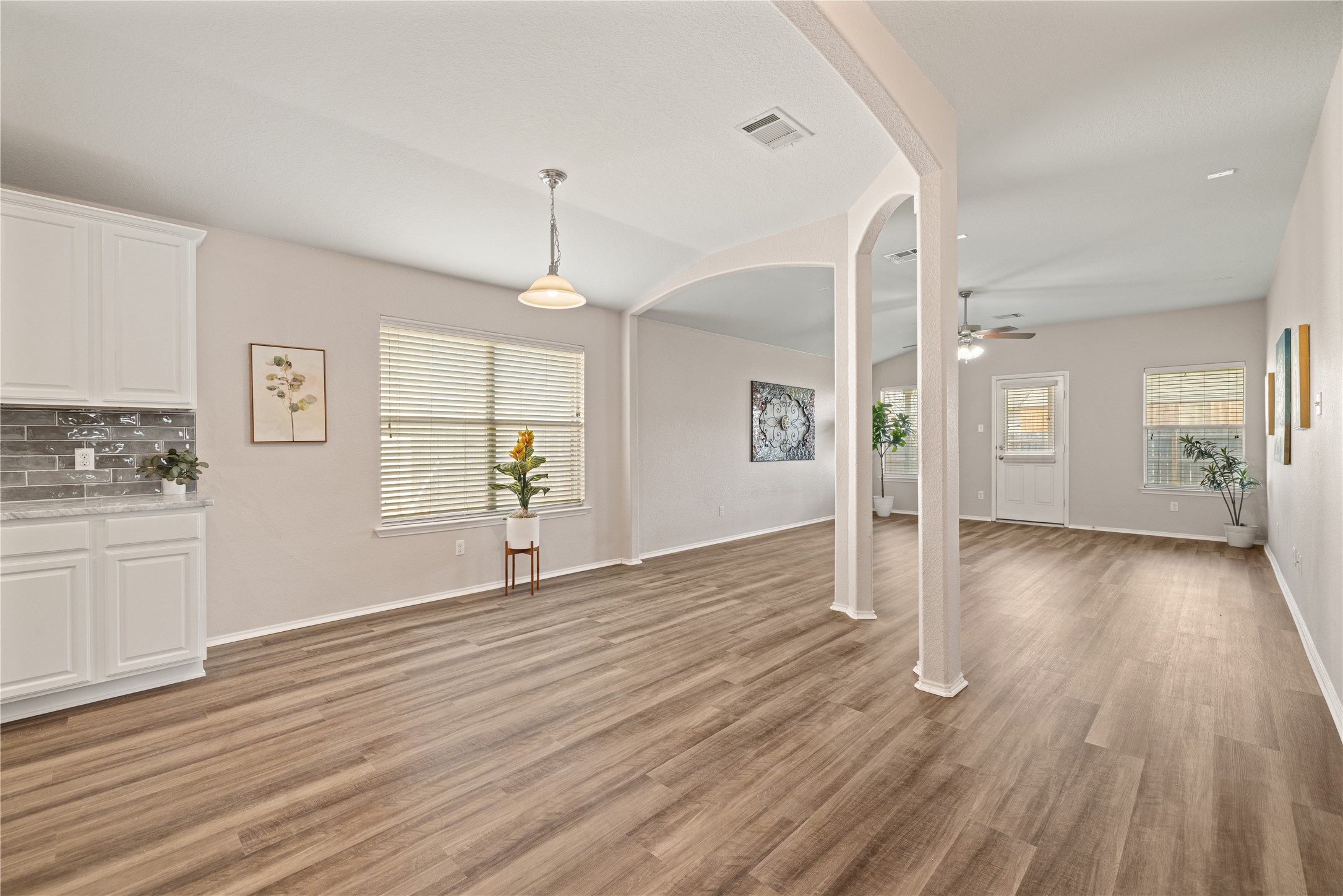 20105 Harrier Flight Trail Pflugerville, TX 78660 - Photo 6 of 35 Unfurnished living room featuring light wood-type flooring, arched walkways, plenty of natural light, and a ceiling fan