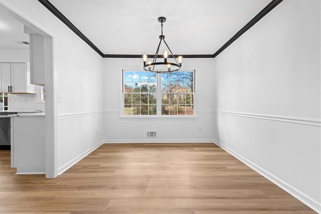 7605 Raleigh Lane Jonesboro, GA 30236 - Photo 15 of 40 an empty room with wooden floor and windows