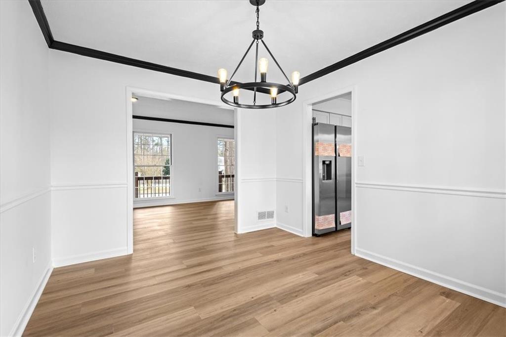 7605 Raleigh Lane Jonesboro, GA 30236 - Photo 16 of 40 a view of a hallway with wooden floor and chandelier