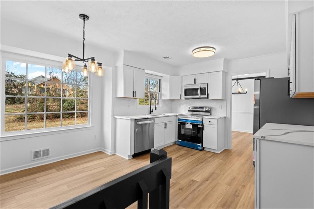 7605 Raleigh Lane Jonesboro, GA 30236 - Photo 17 of 40 a kitchen with granite countertop a refrigerator a stove a sink dishwasher a oven with a dining table and chairs