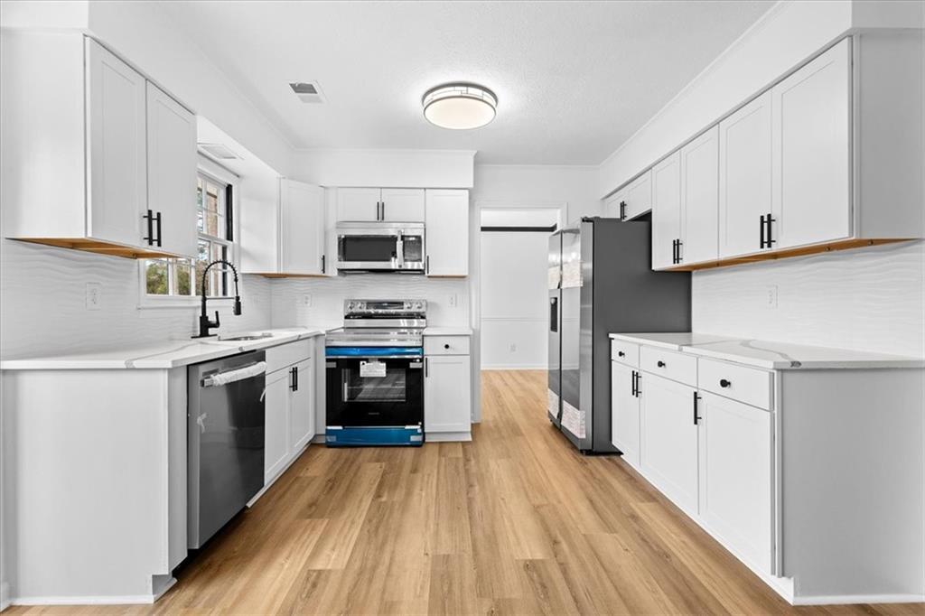 7605 Raleigh Lane Jonesboro, GA 30236 - Photo 19 of 40 a kitchen with white cabinets and stainless steel appliances