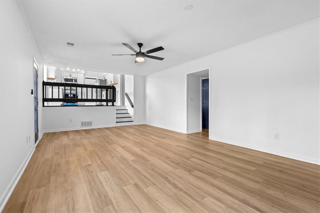 7605 Raleigh Lane Jonesboro, GA 30236 - Photo 22 of 40 a view of empty room with wooden floor and kitchen view