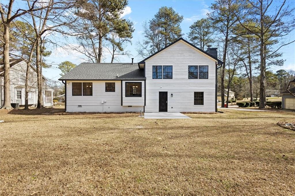 7605 Raleigh Lane Jonesboro, GA 30236 - Photo 7 of 40 a view of a white house with a yard and large trees