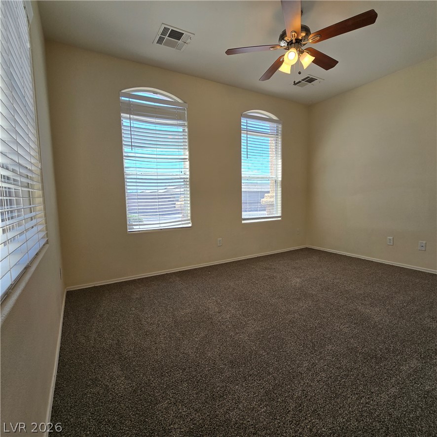 9234 Kingston Road Henderson, NV 89074 - Photo 23 of 38 Well-lit room features soft carpeting and graceful arched windows, perfect for serene living.