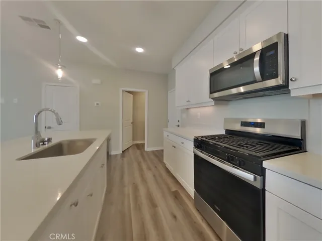 a kitchen with stainless steel appliances granite countertop a sink stove and microwave