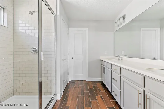 a bathroom with a double vanity sink and mirror