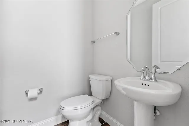 a bathroom with a toilet sink and mirror